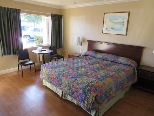 une chambre d'hôtel avec un lit, une table et des chaises dans l'établissement Sandpiper Motel, à Costa Mesa
