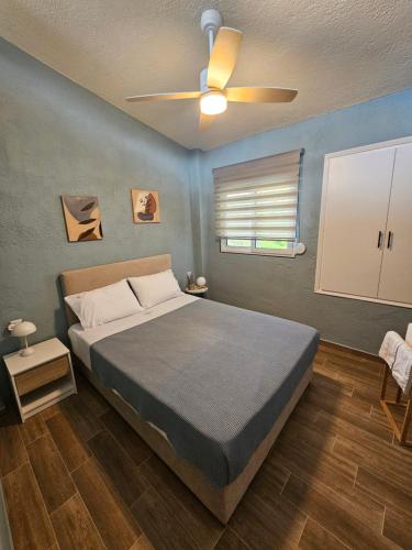 a bedroom with a bed and a ceiling fan at Calma Resort in Skala Fourkas