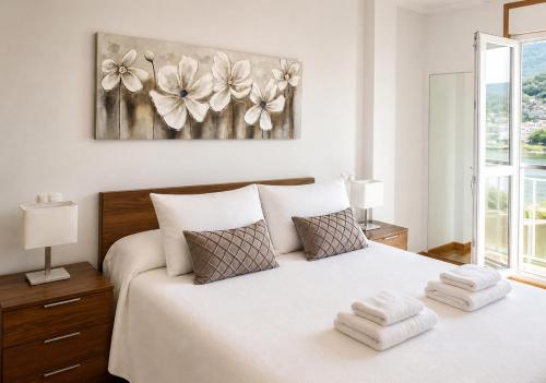 a bedroom with a bed with two towels on it at Apartamento vistas al mar in Viveiro
