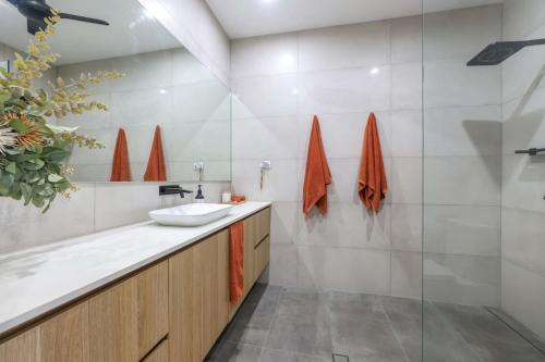 a bathroom with a sink and a mirror at Huge Stylish Townhouse in Stuart Park