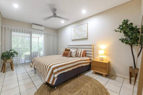 a bedroom with a bed and a large window at Huge Stylish Townhouse in Stuart Park