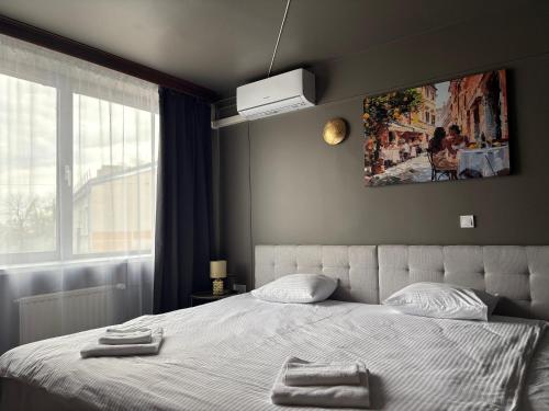 a bedroom with a bed with two towels on it at Hotel Vento in Ventspils