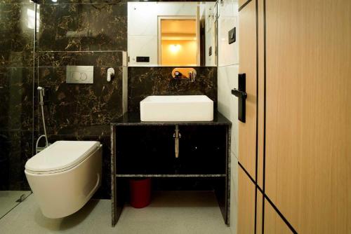 a bathroom with a sink and a toilet and a mirror at Shree Goljyu Palace in Almora