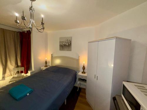 a bedroom with a blue bed and a white cabinet at Spacious Double Room with own Sink in Colindale