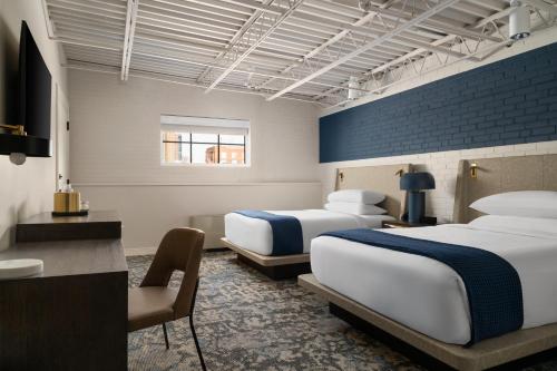 a hotel room with two beds and a desk at The Lantern Hotel Columbia in Columbia