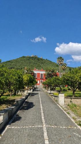 a road leading to a red house with a hill at Bellosguardo Suites in San Paolo Bel Sito
