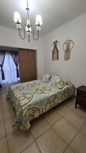 a bedroom with a bed with a blanket on it at Depto Baires Oeste Merlo in Merlo