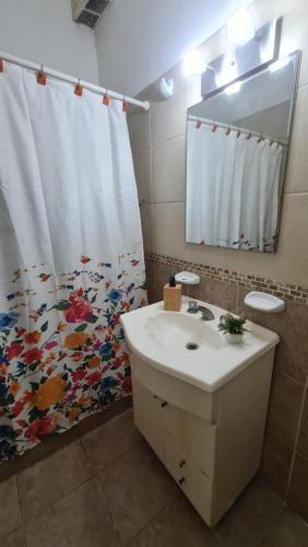 a bathroom with a sink and a shower curtain at Depto Baires Oeste Merlo in Merlo