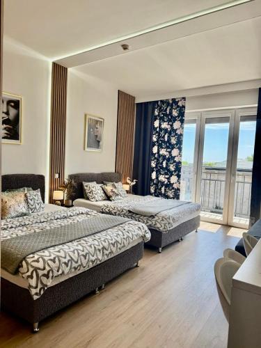 a bedroom with two beds and a couch and windows at Exclusive Apartments Smolna in Warsaw