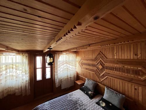 a bedroom with a bed in a wooden room at Садиба "У Пані Галини" з форельним господарством in Kosiv