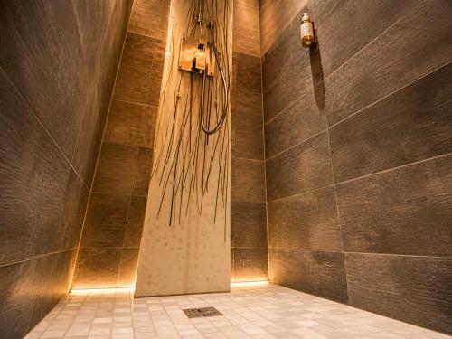 a shower in a bathroom with a shower curtain at Appart' Spa et Sauna Privatif Au Cœur De Beaune in Beaune