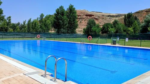 a large swimming pool with blue water at Casa Rural Villa Huerta in Santa María de Huerta