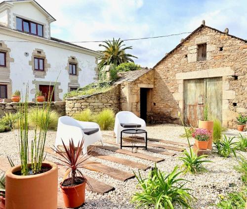 a courtyard with two chairs and plants in front of a building at The Cliffs - PradaBeach in Jove