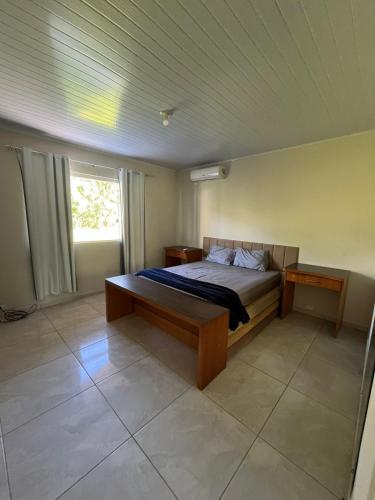 a bedroom with a bed and a window at Chácara com piscina, lazer e muita natureza in Morretes