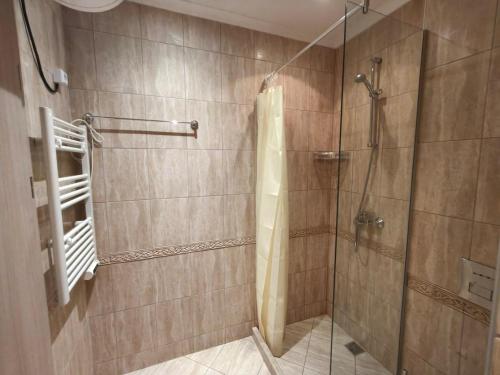 a bathroom with a shower with a glass door at Joy Escape Varna in Varna City