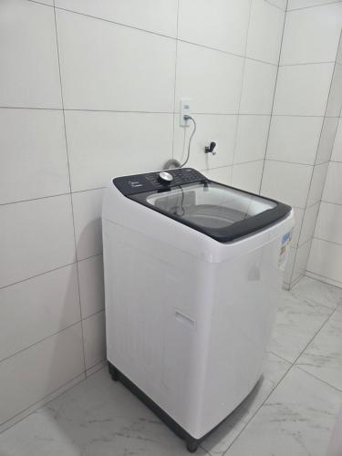 a small white trash can in a white tiled room at Aconchego in Concordia