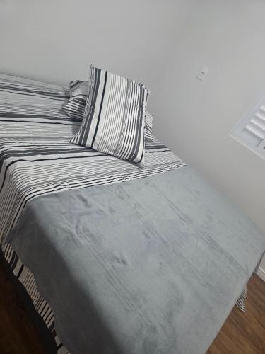 a bed with a black and white comforter and pillow at Aconchego in Concordia