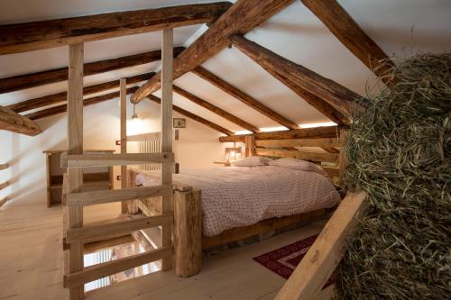 Schlafzimmer mit einem Bett in einem Zimmer mit Holzbalken in der Unterkunft Maso del Fieno in Sant'Orsola Terme