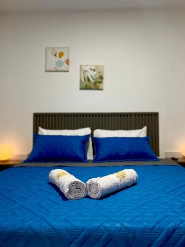two rolls of towels on a blue bed at Hotel Fuente Real Popayán in Popayan