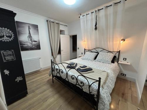 a bedroom with a black and white bed in a room at Maison d'hôtes et gîte - Les 4 saisons de Manon in Tourtoirac