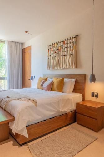 a bedroom with a large bed and a wall with vases at Luxury Penthouse, Rooftop Pool and Lagoon in Bacalar