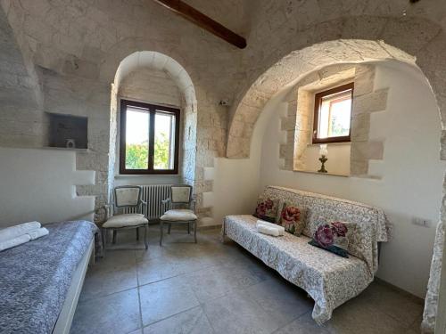 a living room with a couch and chairs in a building at Trullo Cuore di Pietra in Locorotondo