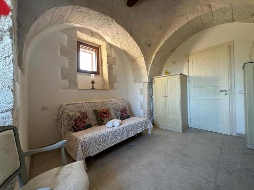 a living room with a couch in a stone room at Trullo Cuore di Pietra in Locorotondo