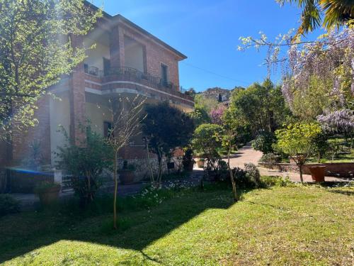 a large brick house with a yard with trees at VILLA La Pineta di Sinalunga, vicino a Montepulciano e Val D'Orcia in Sinalunga
