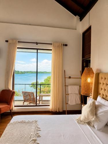 a bedroom with a large window with a view of the water at Zen Koggala by Sugar Coliving in Habaraduwa Central