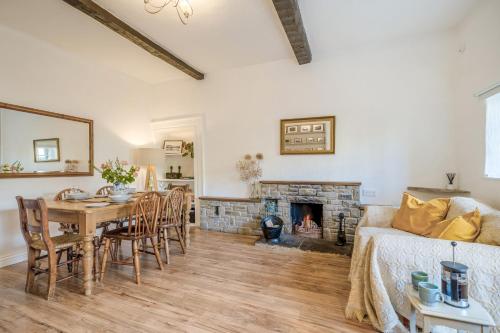 a living room with a table and a fireplace at Forge End Cottage Middleham in Middleham