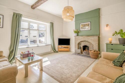 a living room with a couch and a fireplace at Forge End Cottage Middleham in Middleham