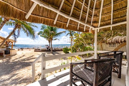 a view of the beach from the porch of a beach house at Hotel Qamar in Tulum