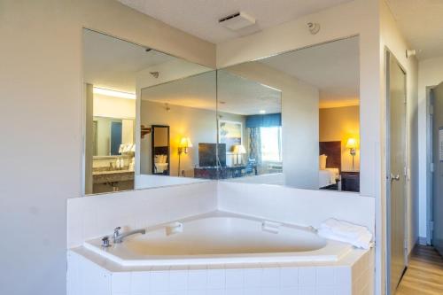 a large bathroom with a tub and a large mirror at Days Inn by Wyndham Sioux City in Sioux City