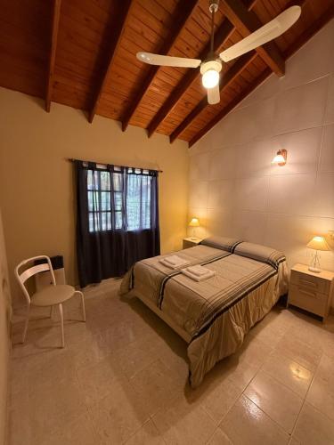 a bedroom with a bed and a ceiling fan at Casa Guemes in Merlo