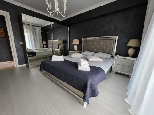 a bedroom with a large bed and a mirror at JohnResidence in Valea Lupului