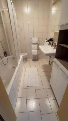 a bathroom with a sink and a tub and a toilet at Ferienwohnung Aiubi in Attnang-Puchheim