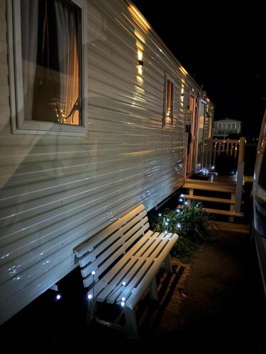 a wooden bench sitting next to a building at night at 15 Maple Rise in Gristhorpe