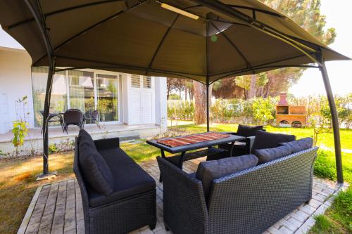 a patio with a table and chairs under a large umbrella at SanPietro Apartments in Draç