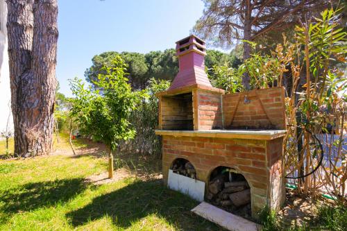 a brick oven sitting in the grass next to a tree at SanPietro Apartments in Draç
