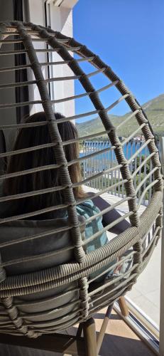 a woman sitting in a hammock on a porch at Arte Oliva in Grebaštica
