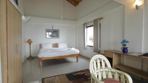 a bedroom with a bed and a desk and two chairs at The himaliyan munros in Rānīkhet