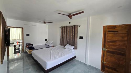 a bedroom with a bed and a ceiling fan at Sunrise Inn in Yelagiri