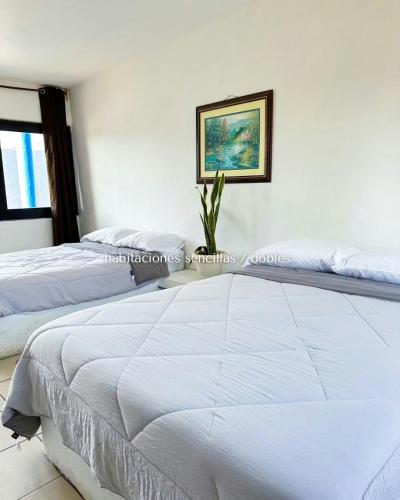 a bedroom with two beds and a picture on the wall at Pacha beach club in Barra de Tuxpan