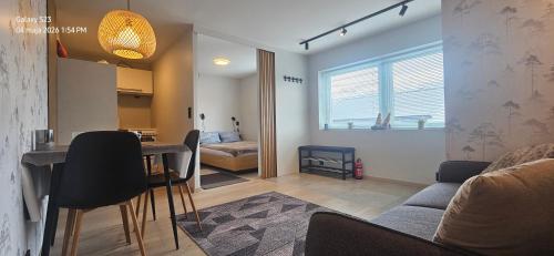 a living room with a couch and a table with chairs at Ramfjord Apartment 2 in Tromsø