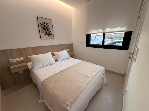 a bedroom with a white bed and a window at El Rincón in Pozoblanco