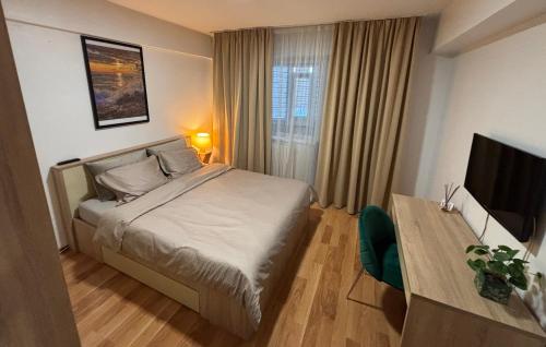 a hotel room with a bed and a television at Sunny Apartment in Constanţa
