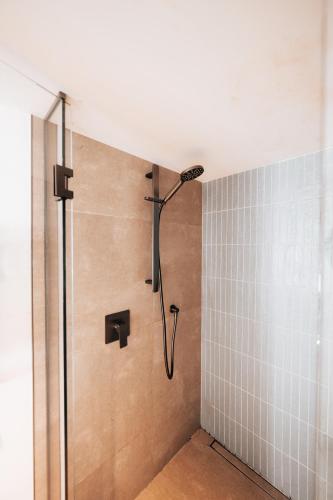 a shower with a shower head in a bathroom at Alpine Chalet - views, fire-pit, central, cosy in Wanaka
