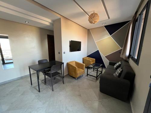 a living room with a black table and chairs at Appartement 3 vue sur mer in Tamraght Ou Fella