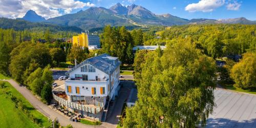 an aerial view of a building with mountains in the background at Aparthotel Belveder in Tatranská Lomnica