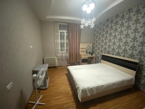a bedroom with a bed and a chandelier at Marita Guesthouse in Batumi